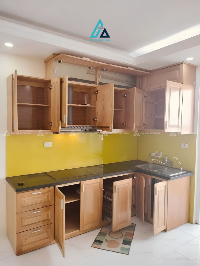 Tủ bếp gỗ chữ L phối kính ốp tường vàng nổi bật cho gia đình 1